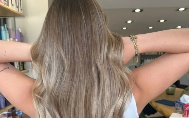 Résultat blond lumineux réalisé par une élève — vue de dos en salon
